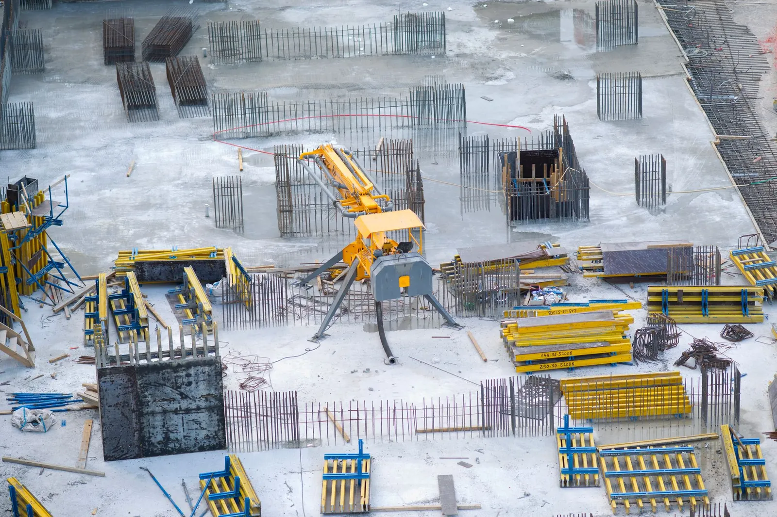 Aerial view of an active construction site with heavy machinery and building materials. Stock photo illustrating Juniper Hotels' expansion story.