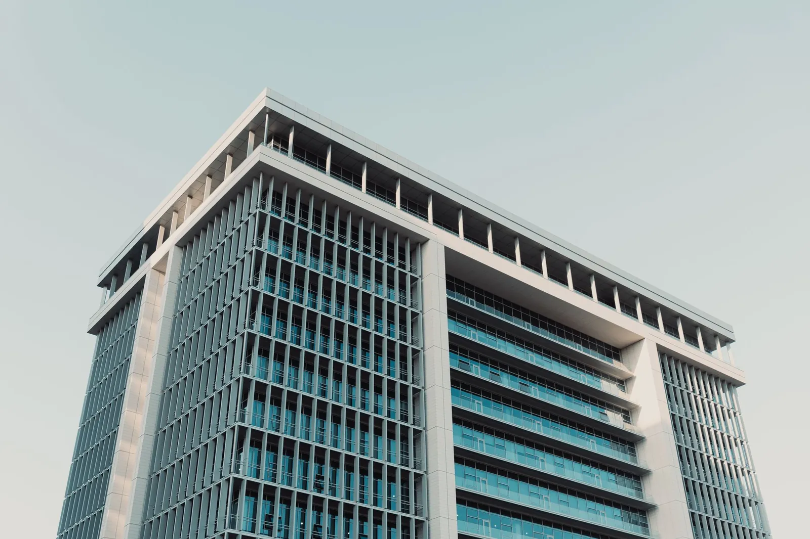 Architectural shot of a modern high-rise office building with a prominent glass facade, shot at daytime. Stock photo illustrating RNFI Services' regulatory approval story.