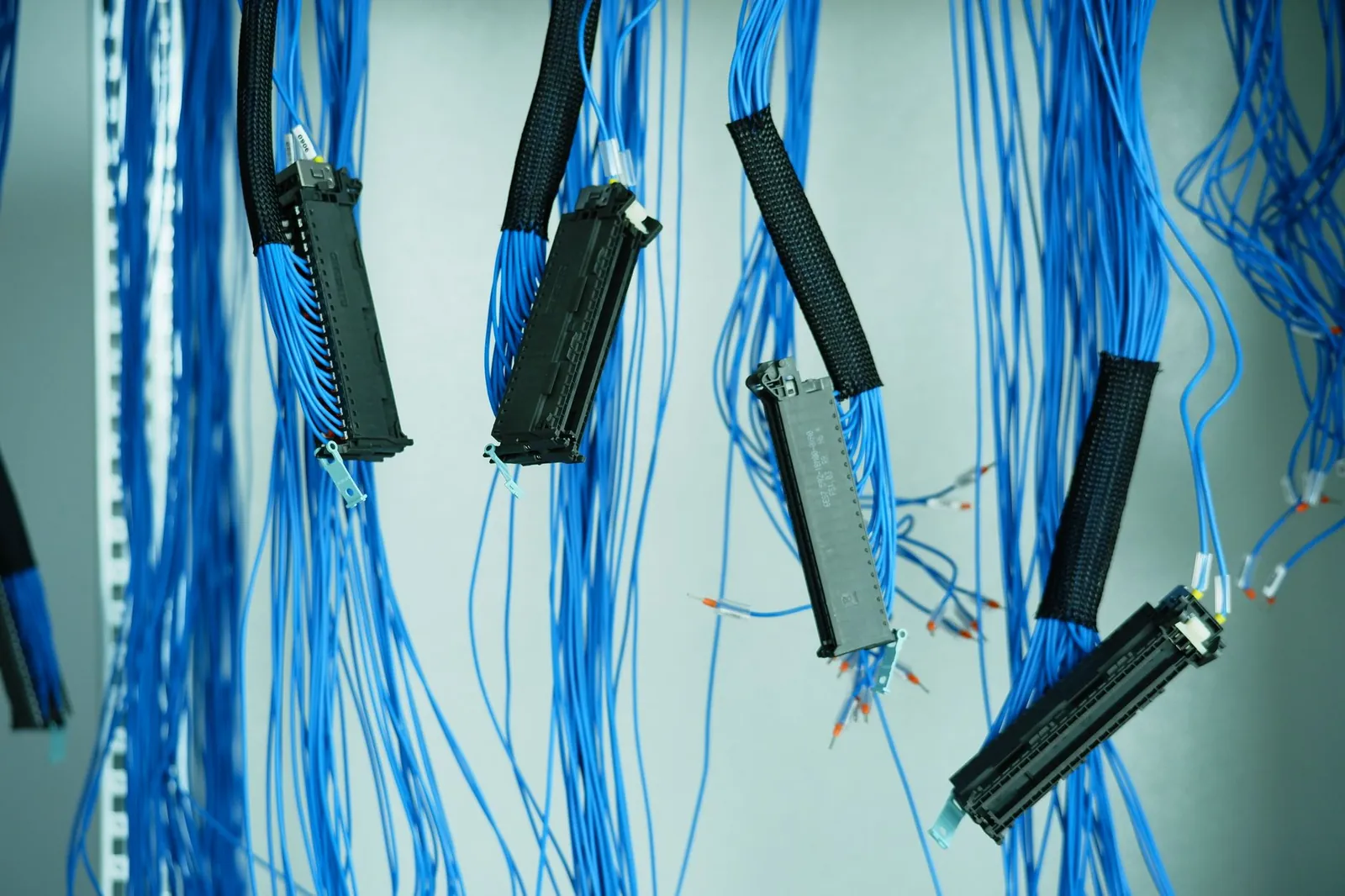 Close-up of blue ethernet cables hanging in a data center, highlighting technology connections. Stock photo illustrating Marine Electricals (India)'s new order story.