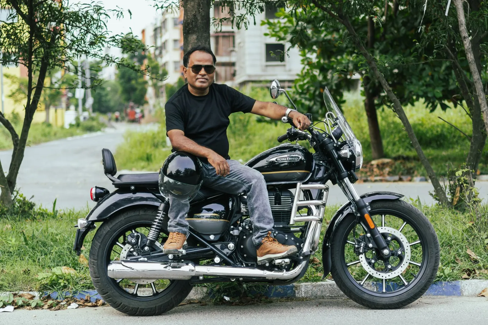 Man sitting on a Royal Enfield motorcycle on a street in Kolkata, India. Stock photo illustrating Eicher Motors' product launched story.