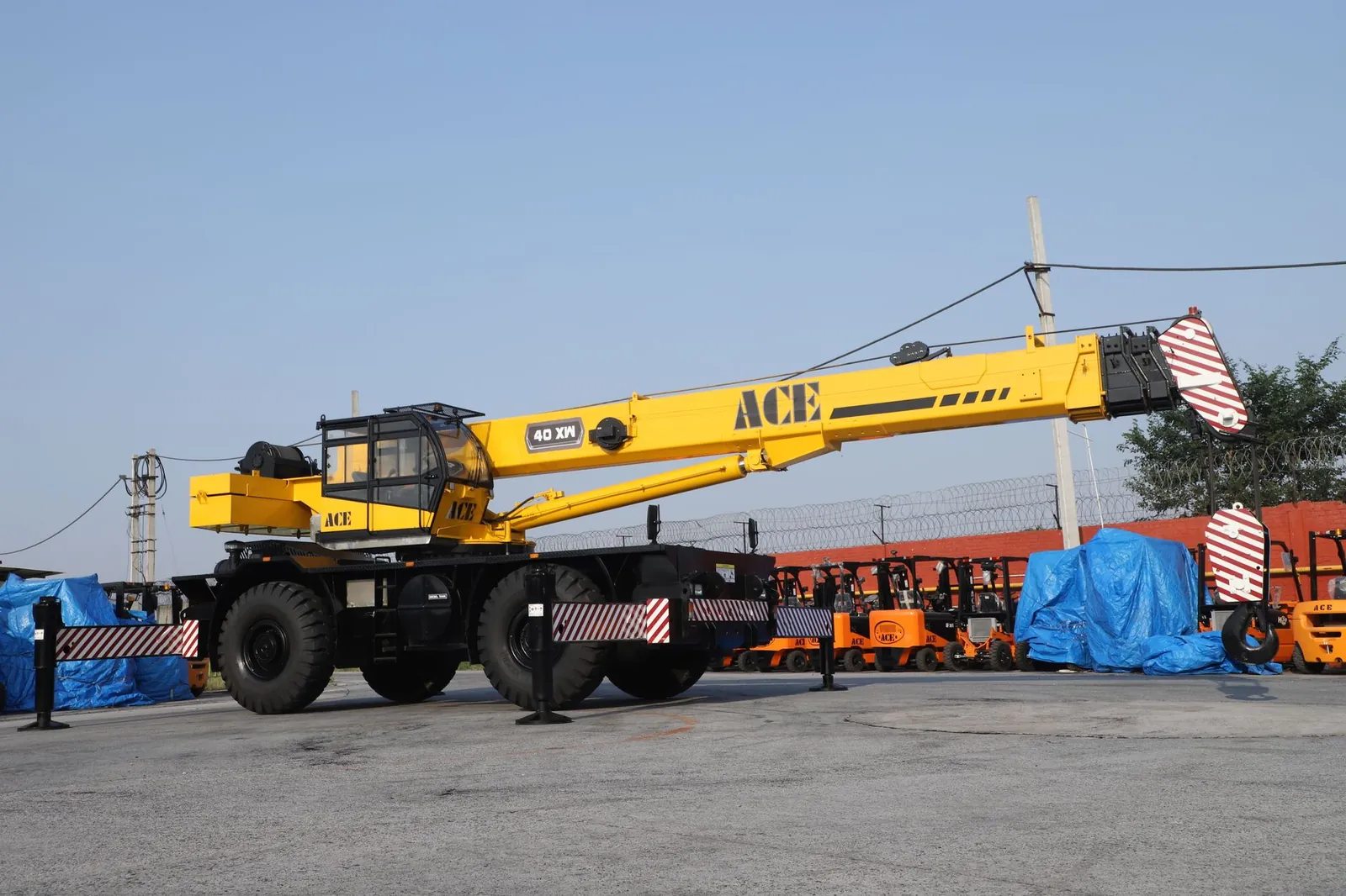 A 40 ton ACE rough terrain crane parked in an industrial yard in Faridabad, India. Stock photo illustrating Trishakti Industries' financial results story.