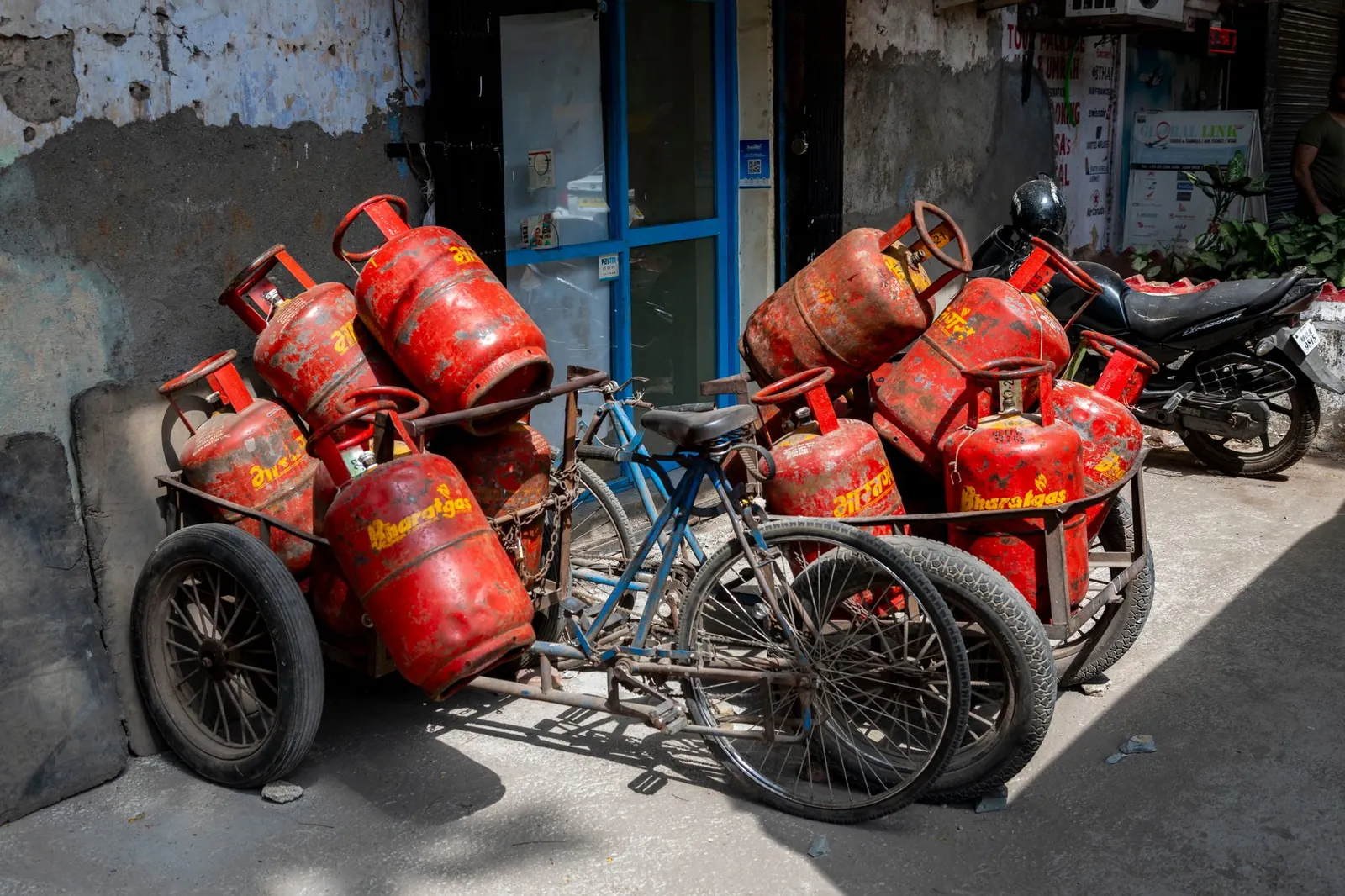 A street in Mumbai featuring a bicycle cart loaded with red gas cylinders, showcasing urban daily life. Stock photo illustrating Indian Oil Corporation's financial results story.