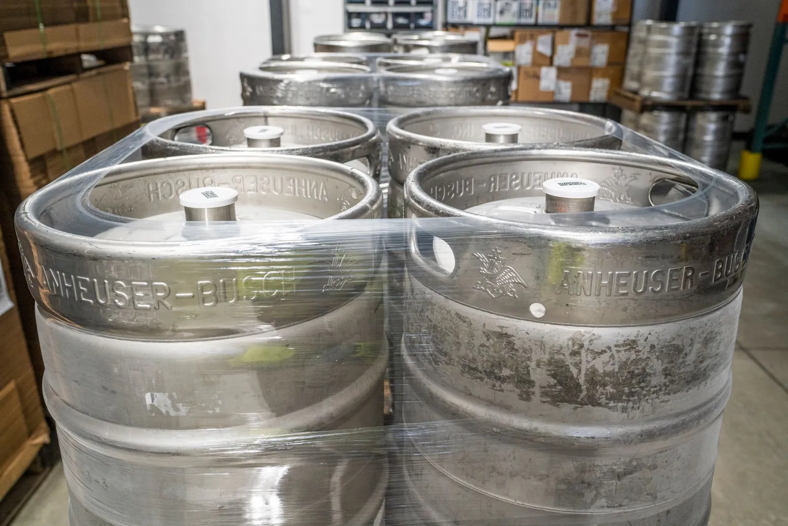 Metal beer kegs stacked and wrapped in plastic in a brewery warehouse, ready for distribution. Stock photo illustrating Rockingdeals Circular Economy's partnership story.