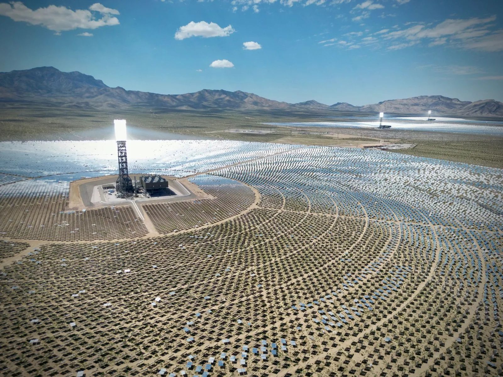 Stunning aerial view of the Ivanpah Solar Electric Generating System with mountainous backdrop. Stock photo illustrating Sterling and Wilson Renewable Energy's new order story.