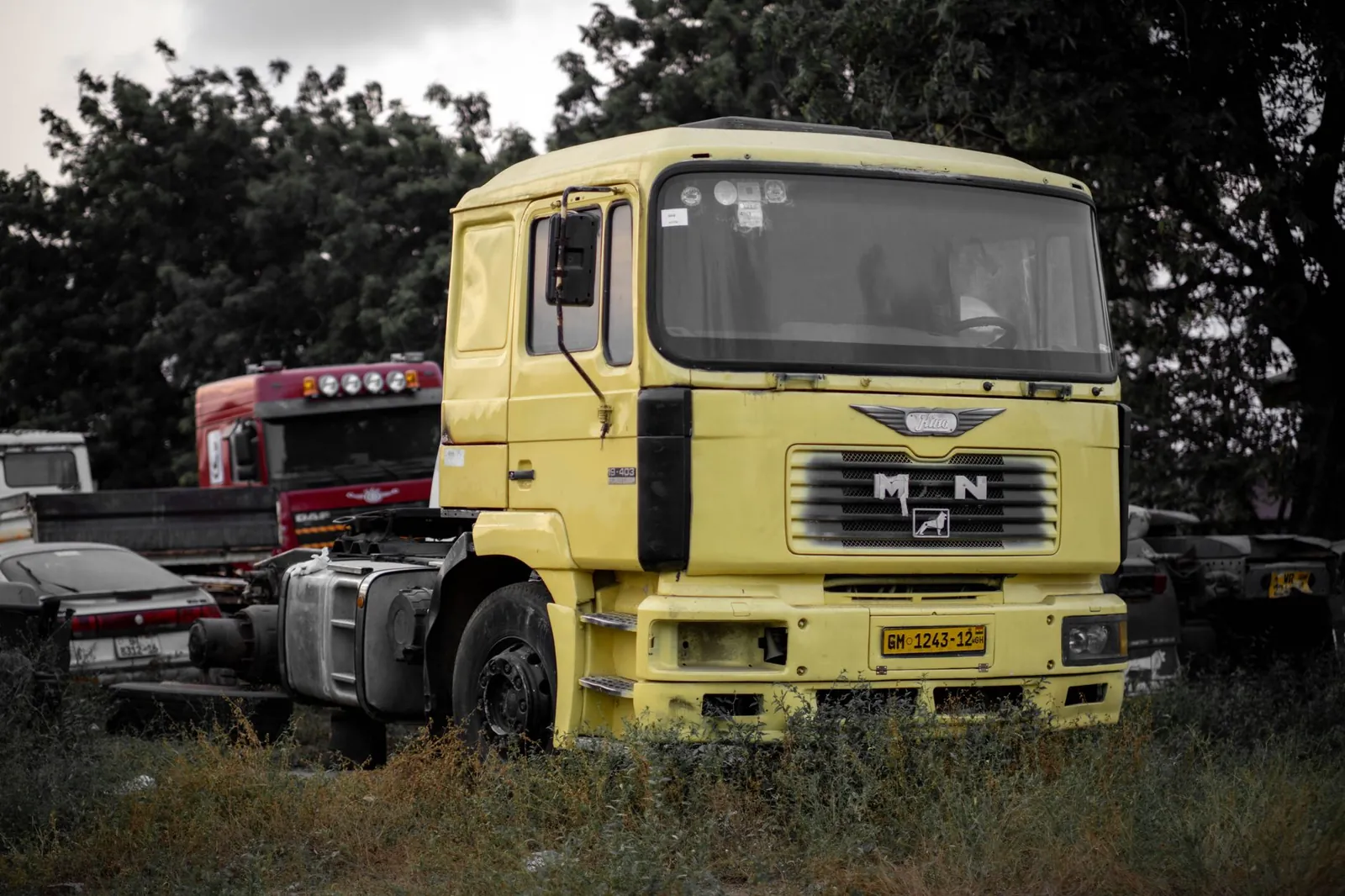 A yellow truck cab parked in an outdoor lot surrounded by other vehicles and trees. Stock photo illustrating Shalibhadra Finance's product launched story.
