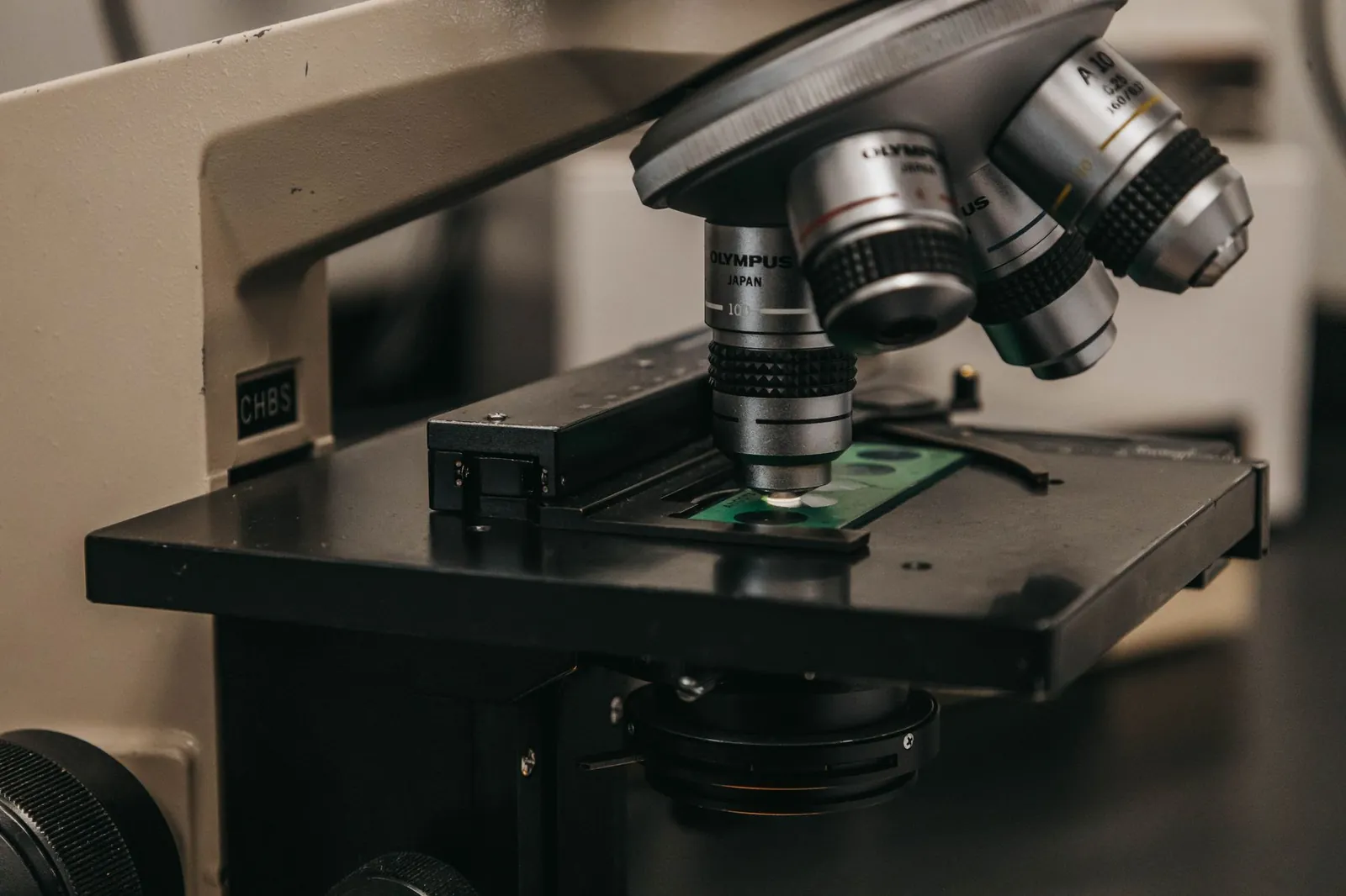 Detailed view of a laboratory microscope, essential for scientific research and analysis. Stock photo illustrating Kabra Drugs' expansion story.