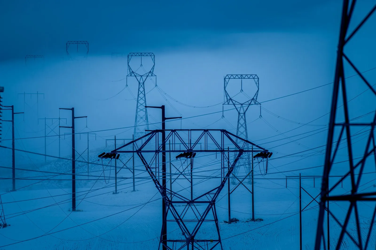 Transmission towers in snowy East Wenatchee, WA, during winter, showcasing electrical infrastructure. Stock photo illustrating HEC Infra Projects' new order story.
