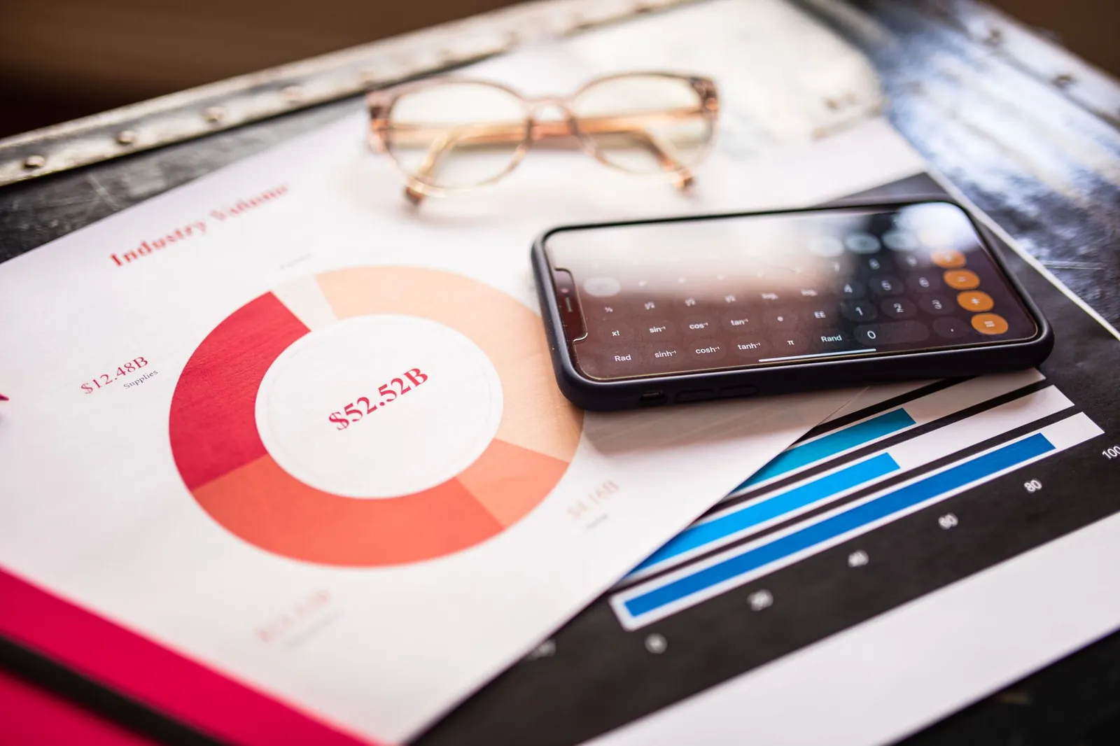 Smartphone on business documents with charts and graphs, illustrating financial analysis. Stock photo illustrating Nureca's product launched story.