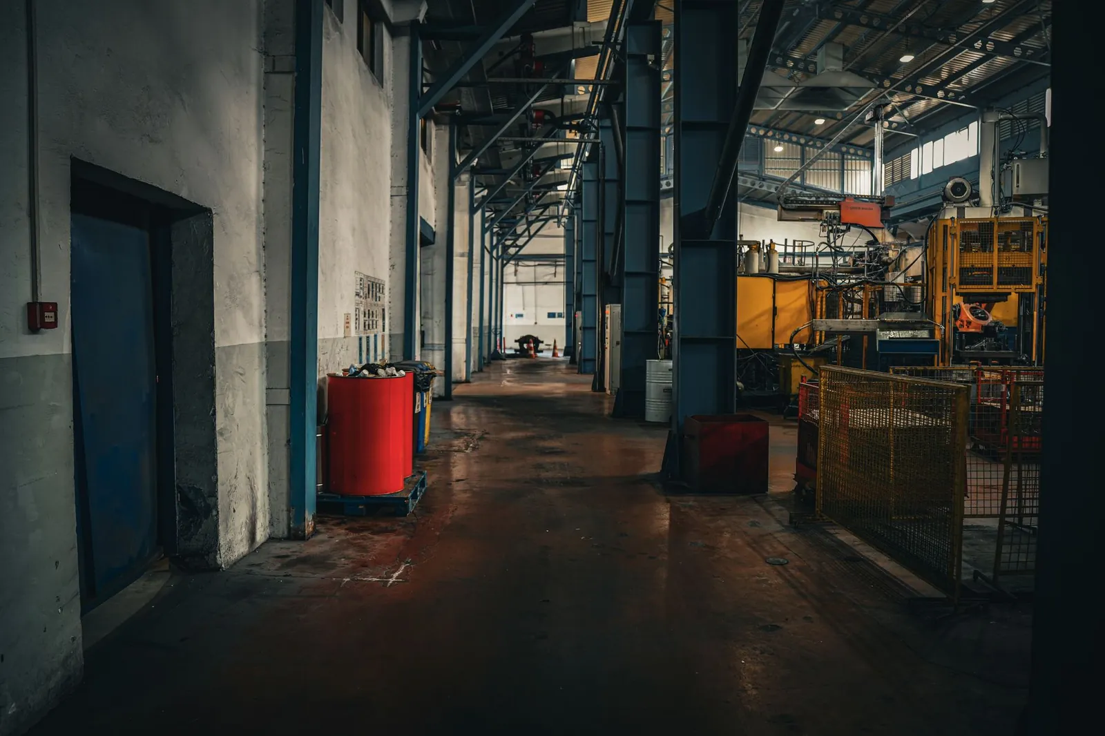 Moody industrial interior showcasing spaciousness and machinery in an empty factory setting. Stock photo illustrating Wheels India's financial results story.