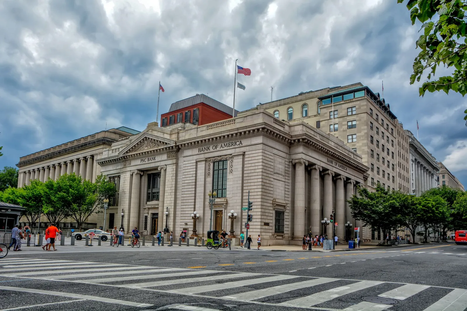 A classic architectural bank building under a dramatic sky in a bustling city environment. Stock photo illustrating Indiabulls' regulatory approval story.