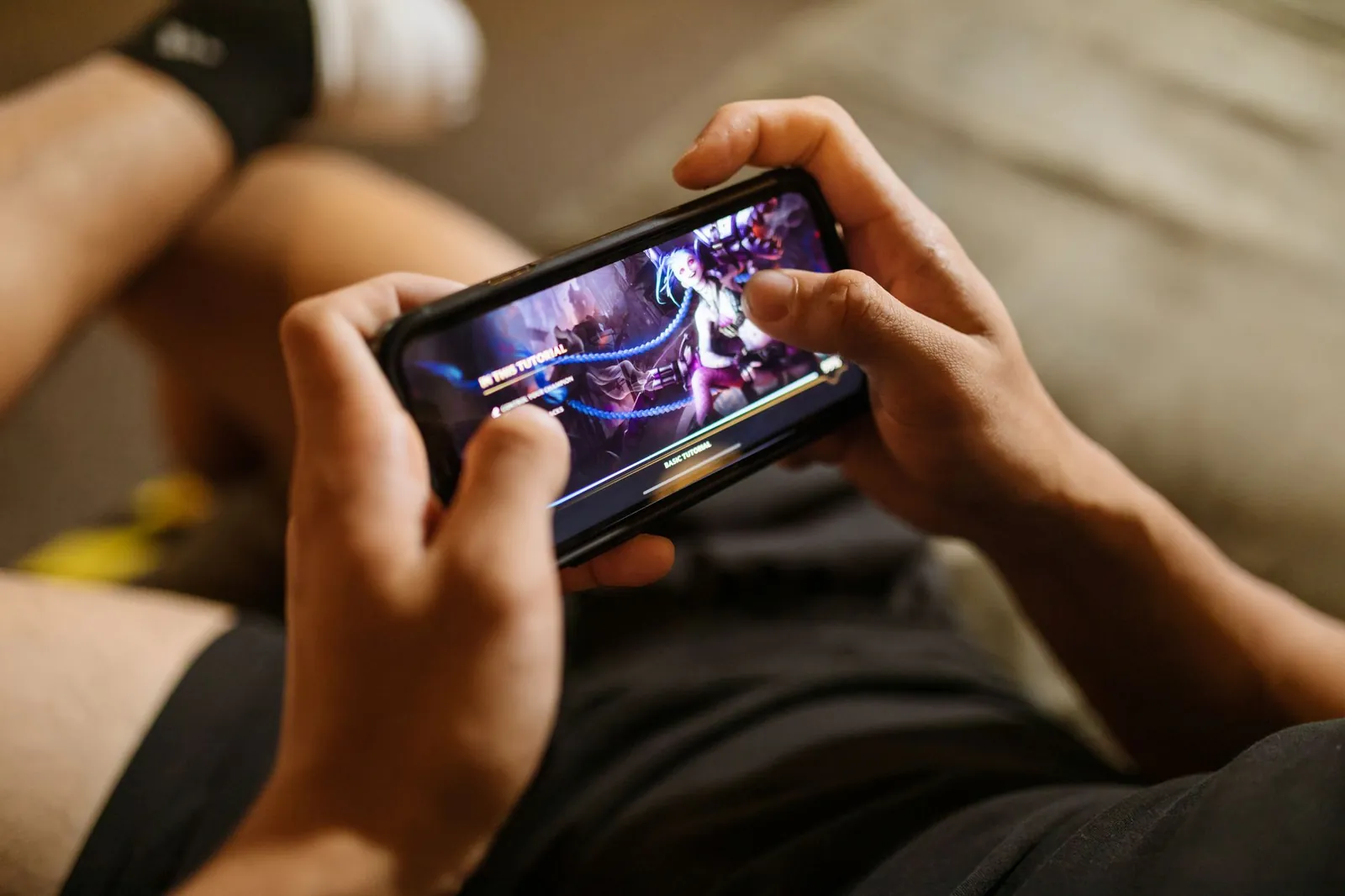 A person playing a mobile video game on a smartphone, focusing on gaming and technology lifestyle. Stock photo illustrating Nazara Technologies' fund raise story.