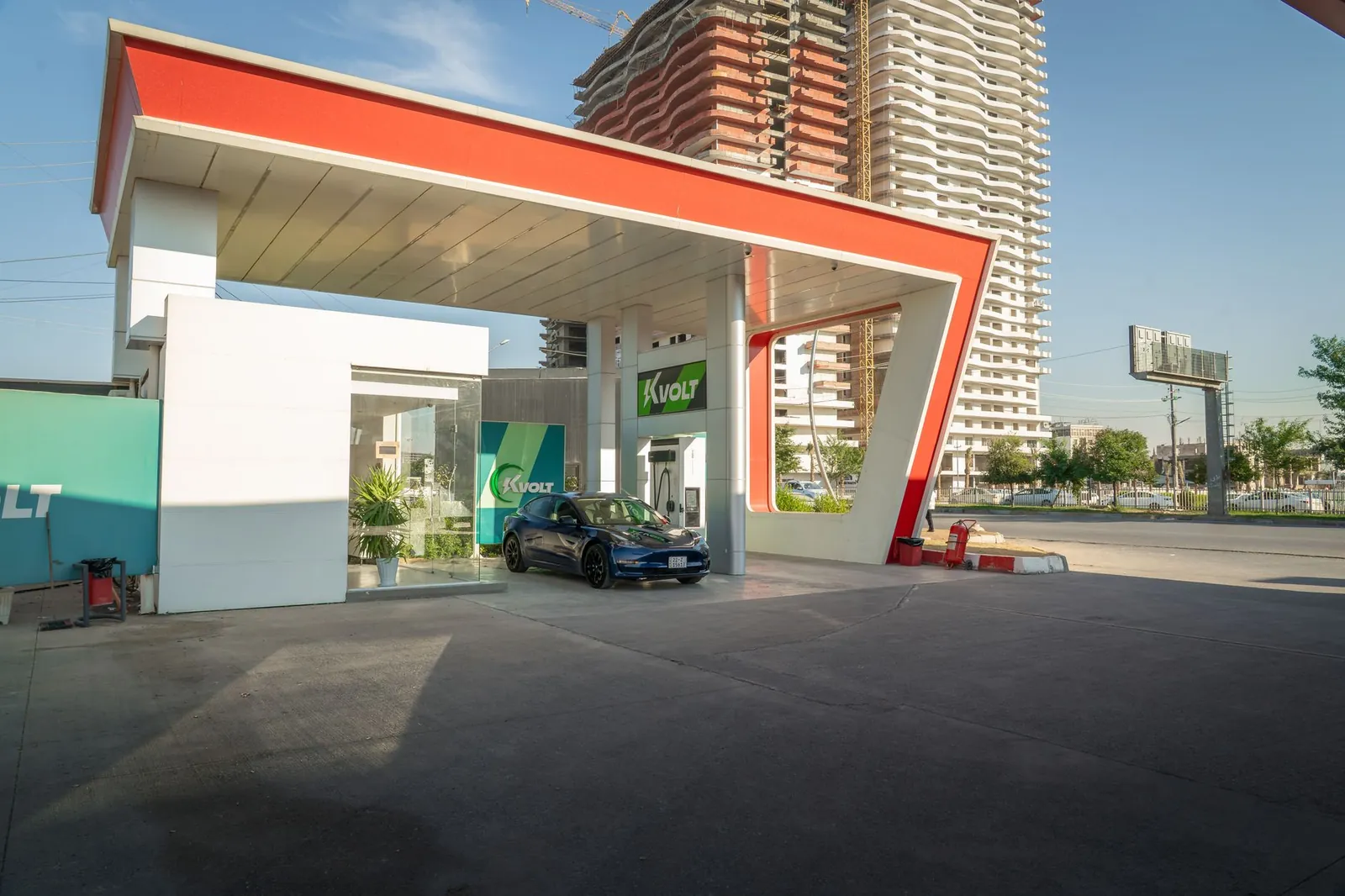 Electric vehicle at a modern charging station in an urban setting, promoting sustainability. Stock photo illustrating Ather Energy's fund raise story.
