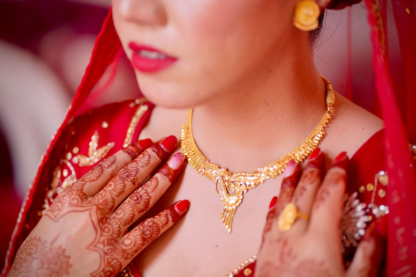 Elegant close-up of a bride showcasing intricate henna and gold jewelry, evoking cultural beauty. Stock photo illustrating Senco Gold's earning call story.