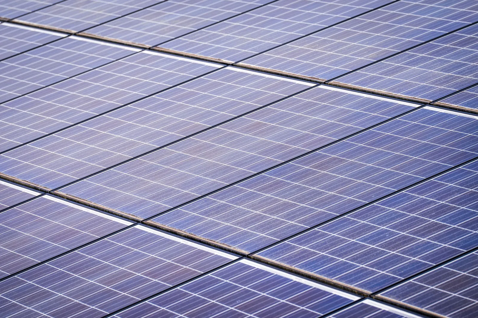 Close-up of a solar panel array capturing renewable energy on a sunny day. Stock photo illustrating KPI Green Energy's production started story.