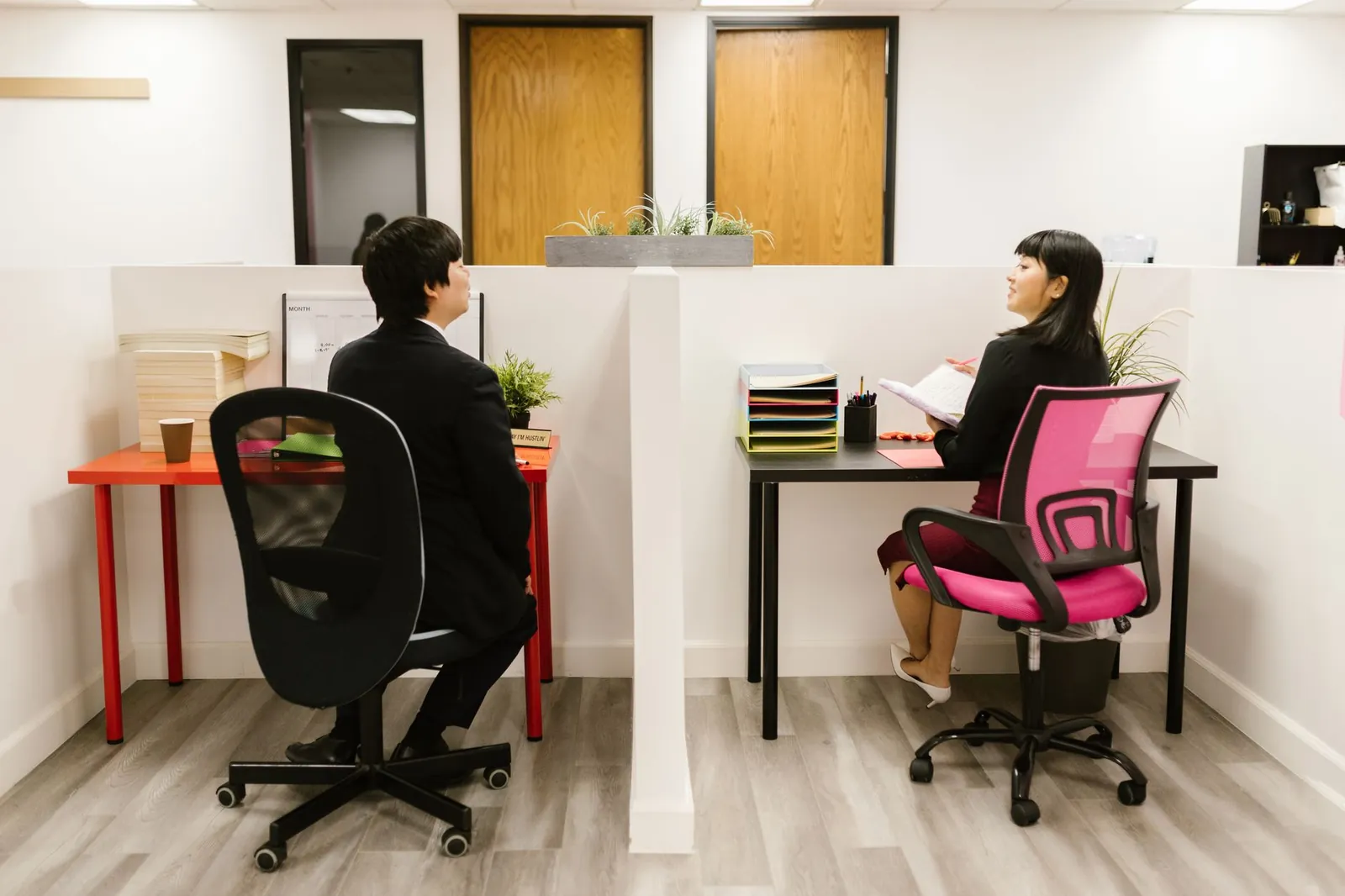 Asian coworkers discussing in a modern office setup, highlighting teamwork and collaboration. Stock photo illustrating Dev Accelerator's expansion story.