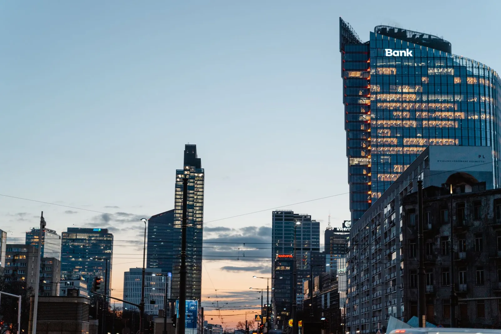 A contemporary city skyline featuring tall buildings and a prominent bank at dusk. Stock photo illustrating ICICI Bank's fund raise story.