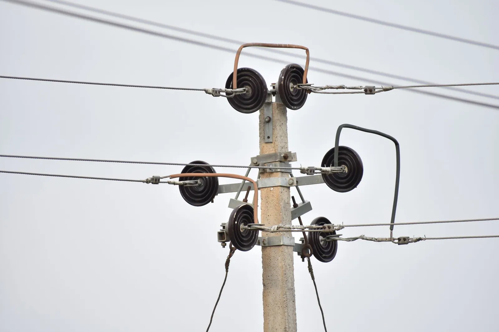 High-resolution image of a utility pole with insulators and power lines against a clear sky. Stock photo illustrating Yash Highvoltage's partnership story.