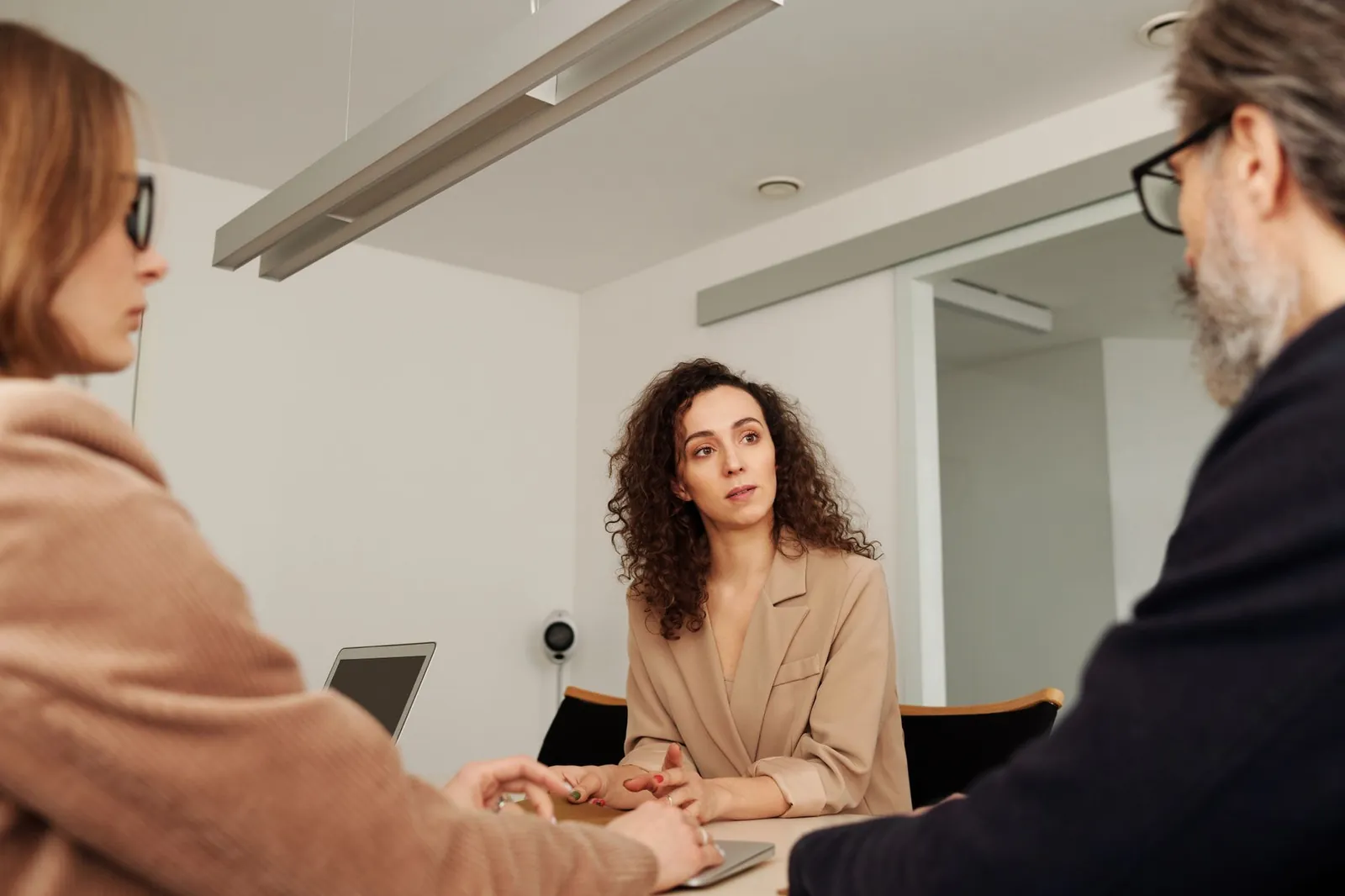 Professionals engage in a focused discussion during a business meeting in a modern office setting. Stock photo for the ALFA News guide: Price Sensitive vs Routine Filings: A SEBI Disclosure Guide.