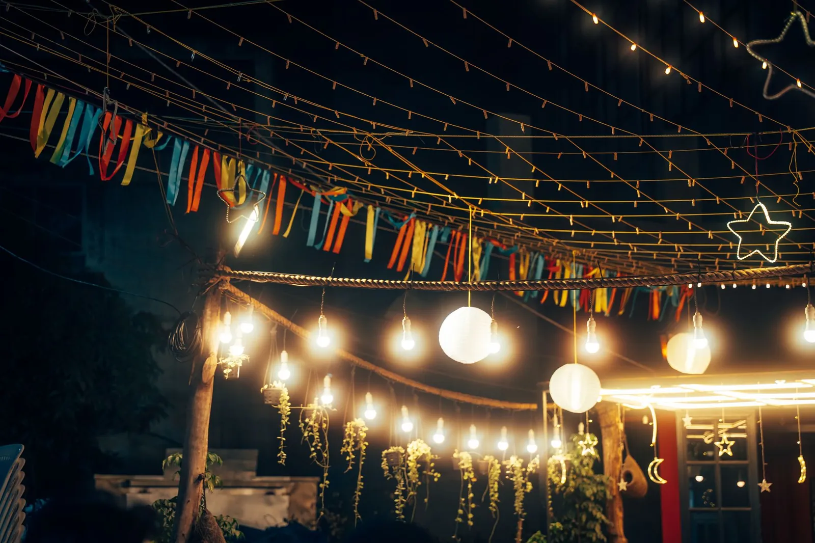 Outdoor string lights and decorations create a festive nighttime ambiance. Stock photo illustrating Crompton Greaves Consumer Electricals' product launched story.