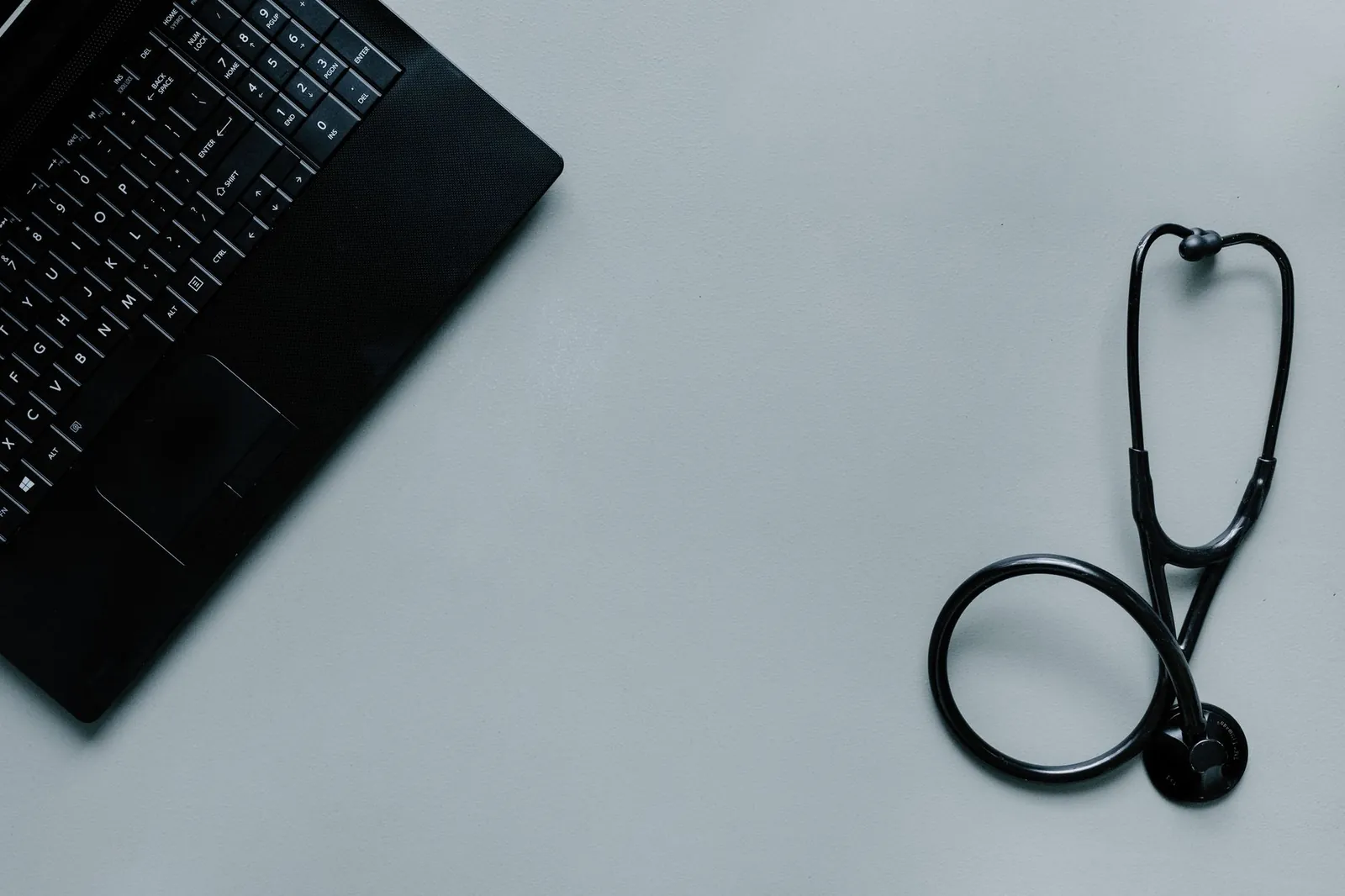 Minimalist image depicting a laptop and stethoscope representing telemedicine and digital health. Stock photo illustrating AVI Polymers' product launched story.