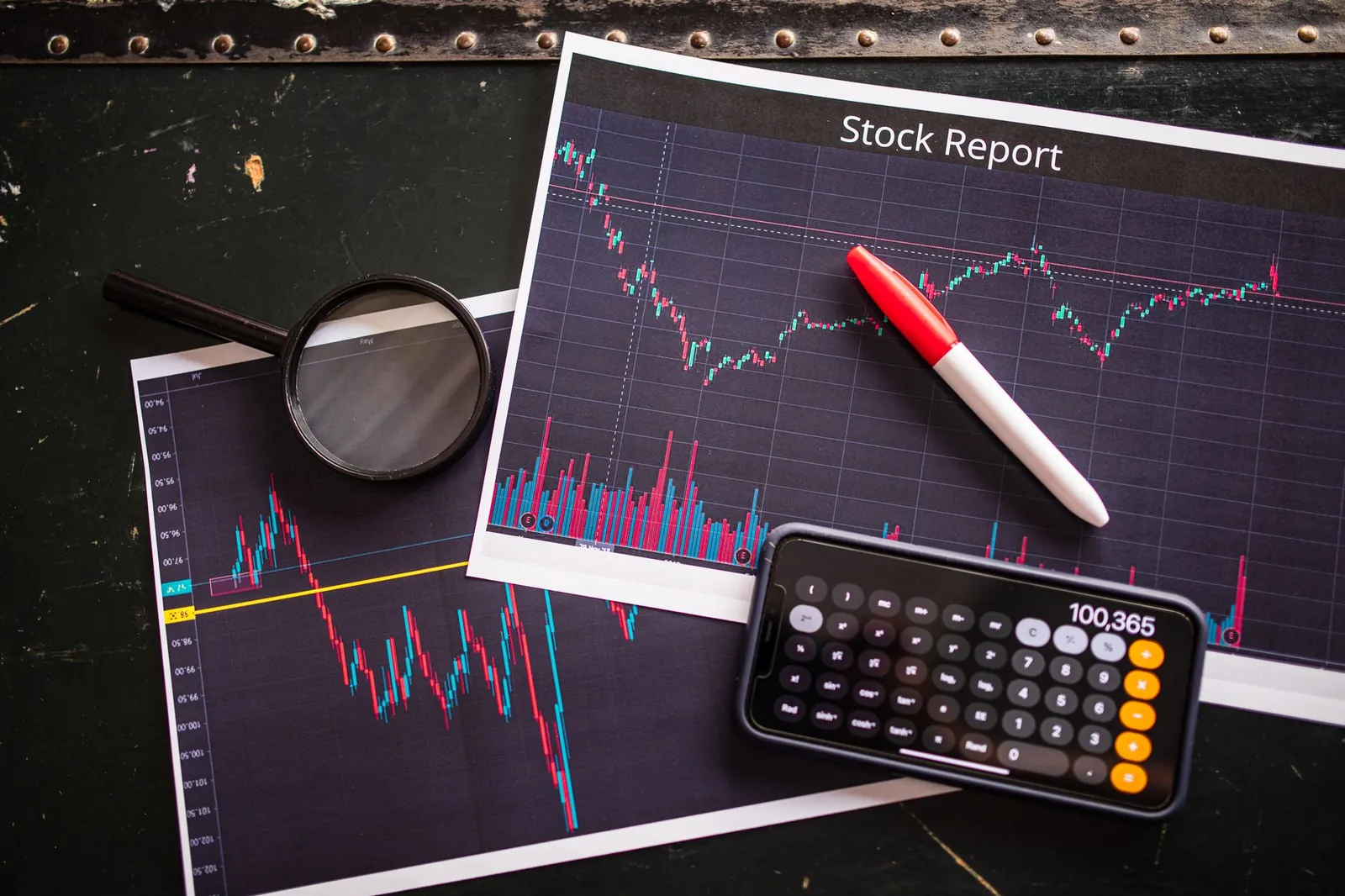 Stock report with charts, calculator, and magnifying glass for financial analysis. Stock photo for the ALFA News guide: How to Set Up Stock Alerts in India.