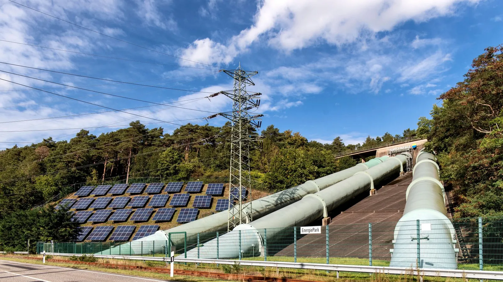 Solar panels and industrial pipes in Geesthacht's EnergiePark on a sunny day. Stock photo illustrating Adani Green Energy's production started story.