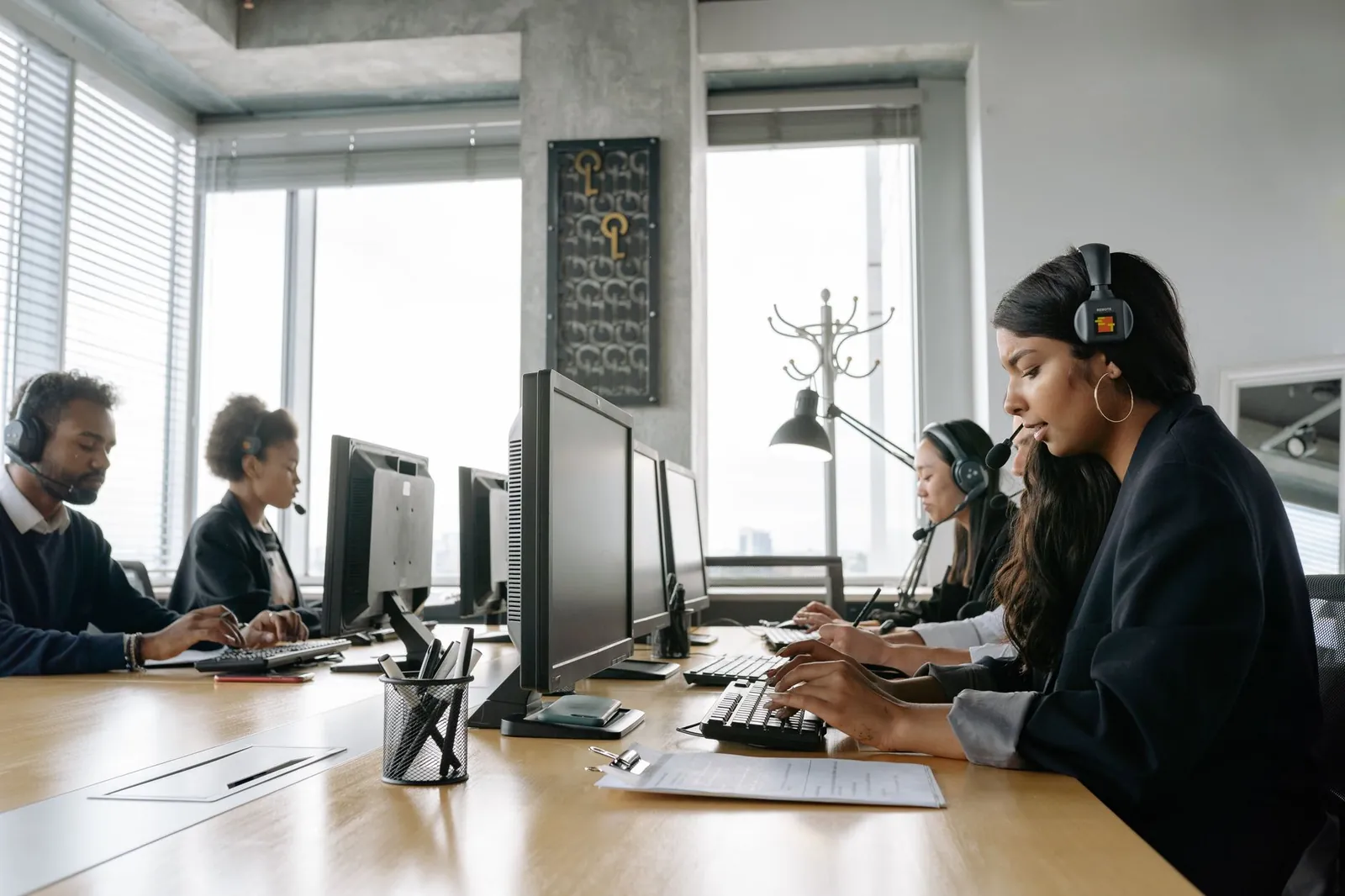 A team of call center agents working in a modern office with headsets and computers. Stock photo illustrating HCL Technologies' partnership story.
