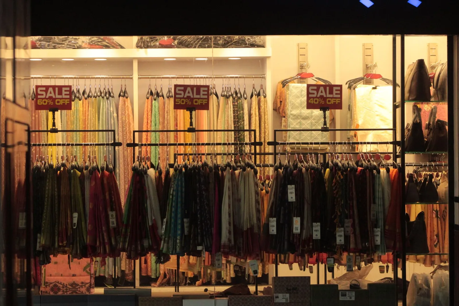 Vibrant clothing store interior showcasing colorful fabrics with sale discount signs. Stock photo illustrating V2 Retail's expansion story.