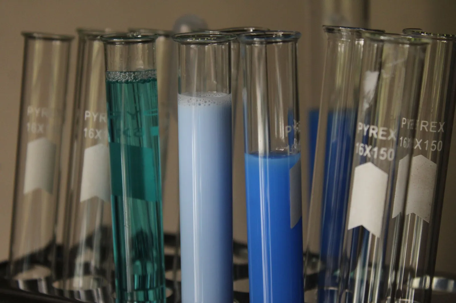 Close-up of colorful chemical solutions in glass test tubes in a laboratory setting. Stock photo illustrating Resonance Specialties' financial results story.