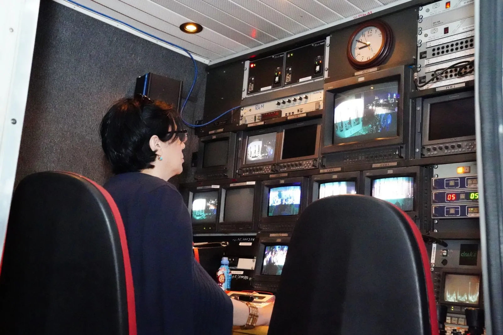 A professional in a TV broadcast control room with multiple screens and equipment. Stock photo illustrating Zee Entertainment Enterprises' fund raise story.