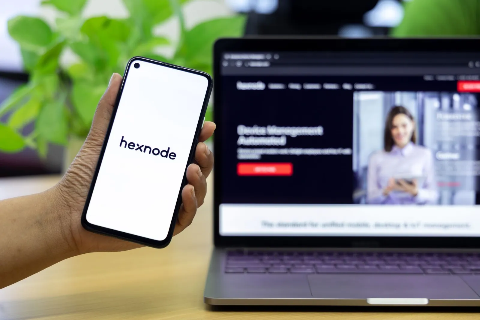 A close-up of a smartphone showing a mobile management app in front of a laptop screen. Stock photo illustrating Mobavenue AI Tech's product launched story.