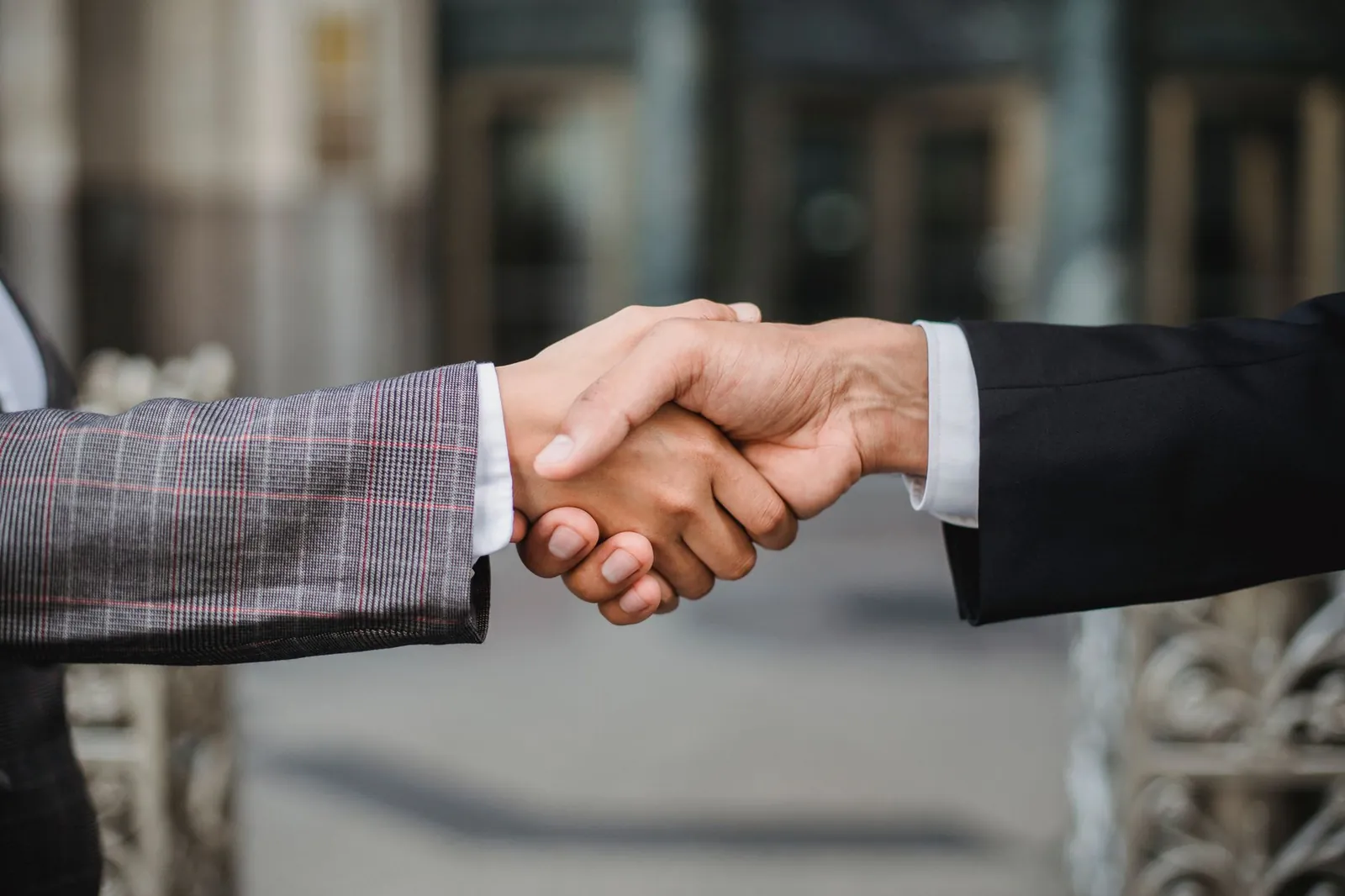 A close-up of two businesspeople shaking hands, symbolizing cooperation and partnership. Stock photo illustrating GACM Technologies' partnership story.