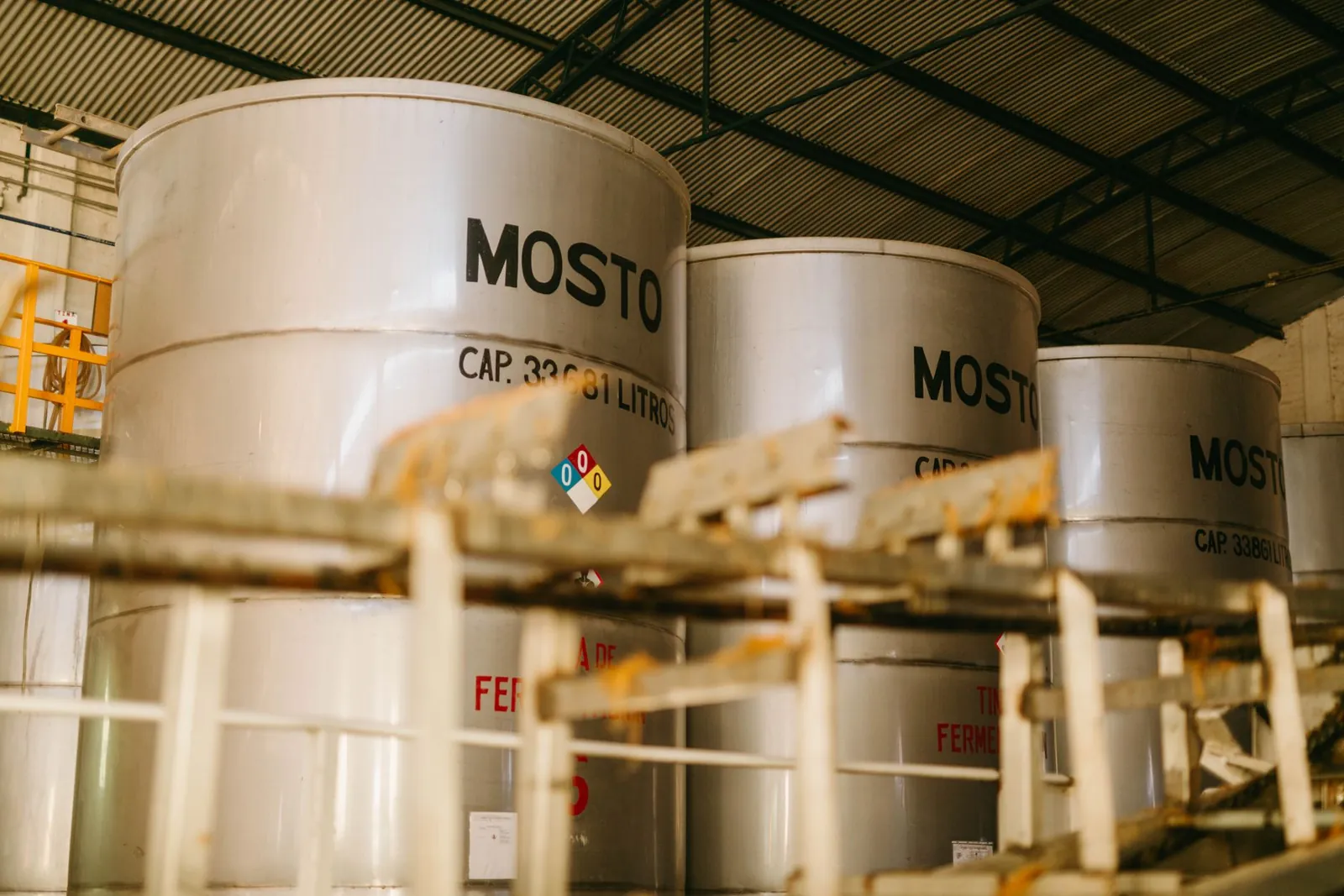 Interior view of an industrial tequila distillery with large metal containers labeled 'Mosto'. Stock photo illustrating BCL Industries' production started story.