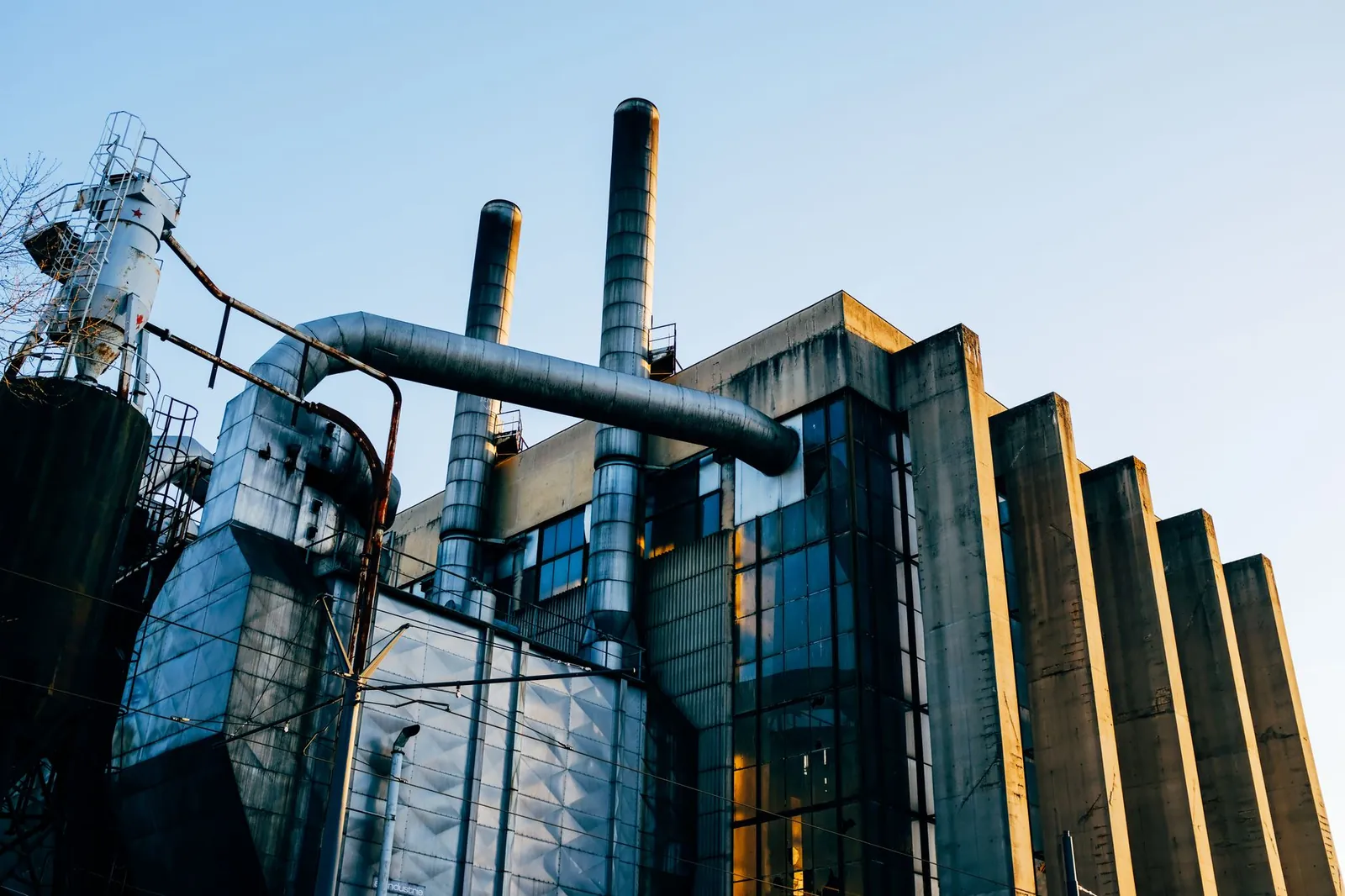 Low angle exterior of factory located on city street under blue sky in evening time. Stock photo illustrating Coal India's partnership story.
