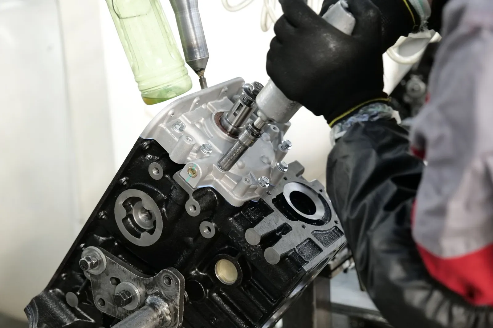 Skilled mechanic working on engine assembly with precision tools in factory setting. Stock photo illustrating Remsons Industries' new order story.