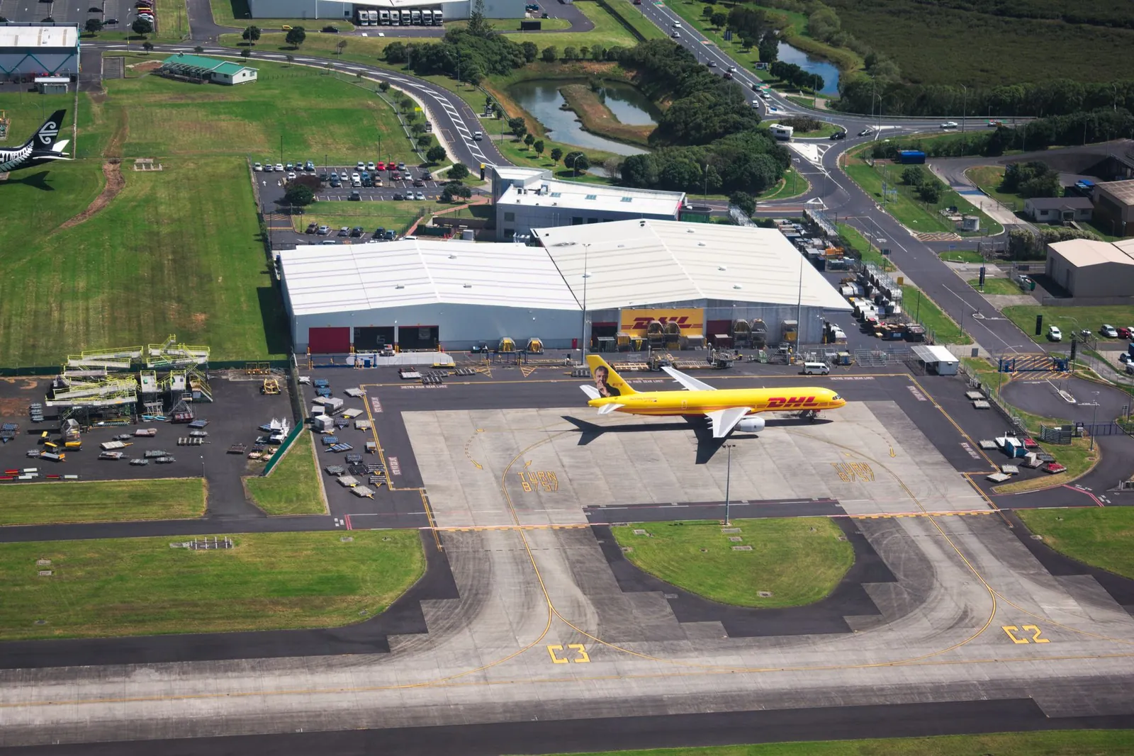 Aerial photo showcasing DHL airplane and hangar facilities in a busy airport setting. Stock photo illustrating INOX India's new order story.