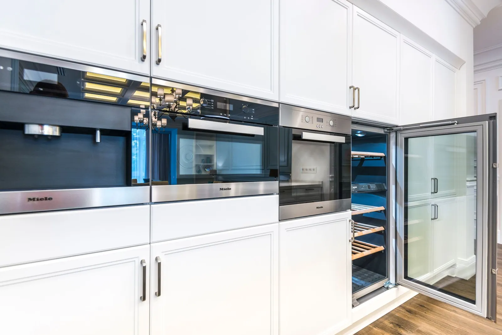 A sleek contemporary kitchen featuring built-in appliances and minimalist white cabinets for a spacious look. Stock photo illustrating Crompton Greaves Consumer Electricals' product launched story.