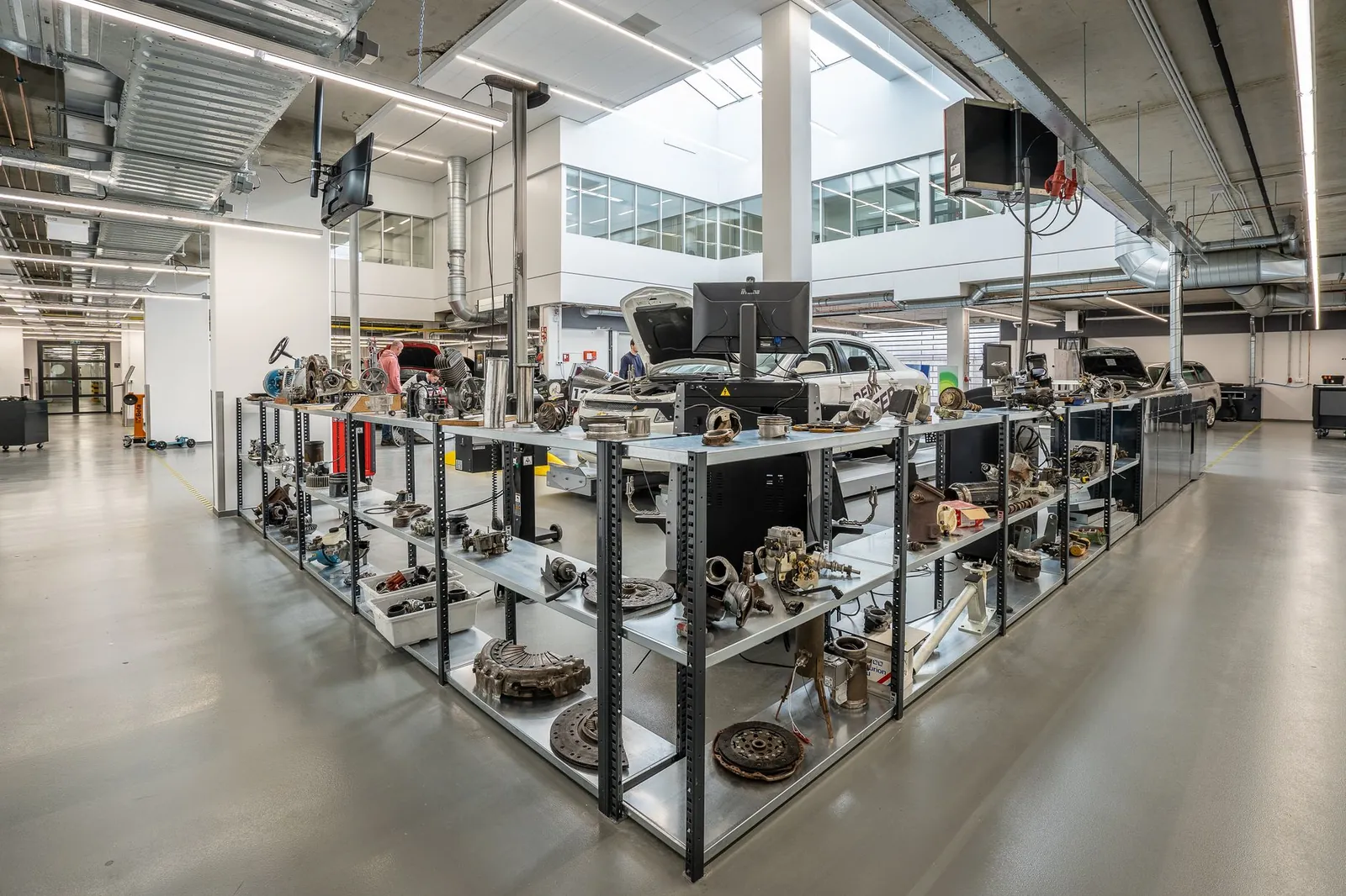 Spacious auto workshop showcasing various car parts and repair equipment. Stock photo illustrating JBM Auto's financial results story.