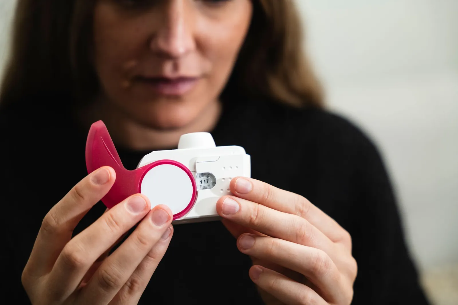 Close-up of a woman holding a medical inhaler device for respiratory conditions. Stock photo illustrating Aurobindo Pharma's product launched story.