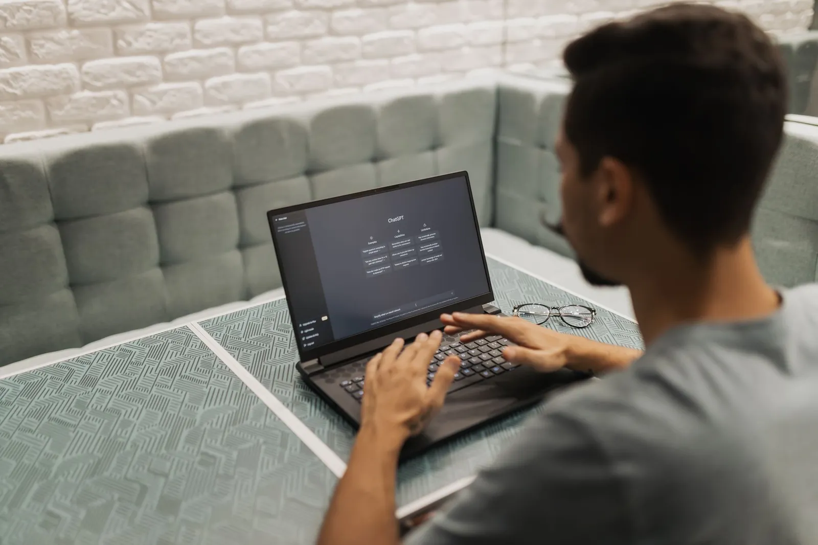 A man working on a laptop in a cozy, modern office space with a focus on technology. Stock photo illustrating RateGain Travel Technologies' earning call story.