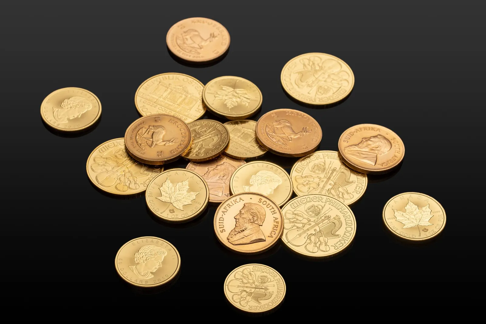 Close-up of various international gold coins on a reflective black surface, showcasing global currency. Stock photo illustrating Finkurve Financial Services' earning call story.