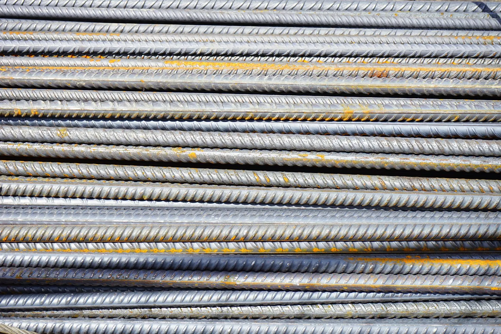 Close-up of stacked rusty steel reinforcing bars used in construction. Stock photo illustrating Steel Exchange India's earning call story.
