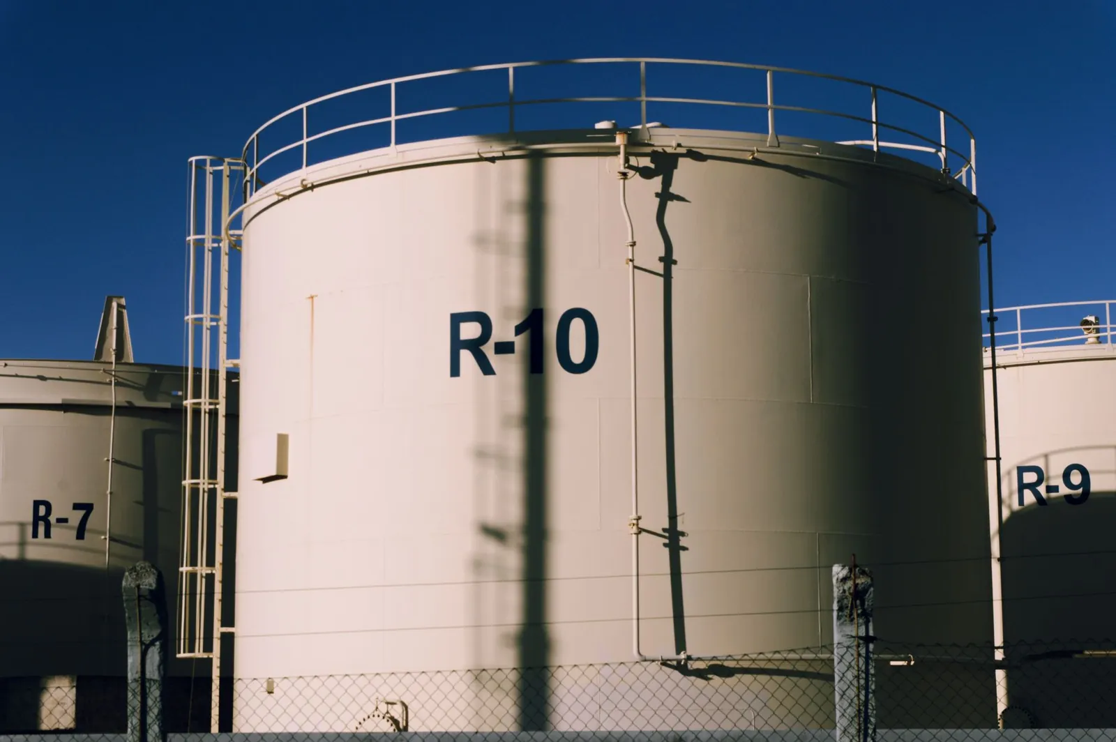 Large industrial storage tanks under blue skies, highlighting metal structures. Stock photo illustrating Inox India's new order story.