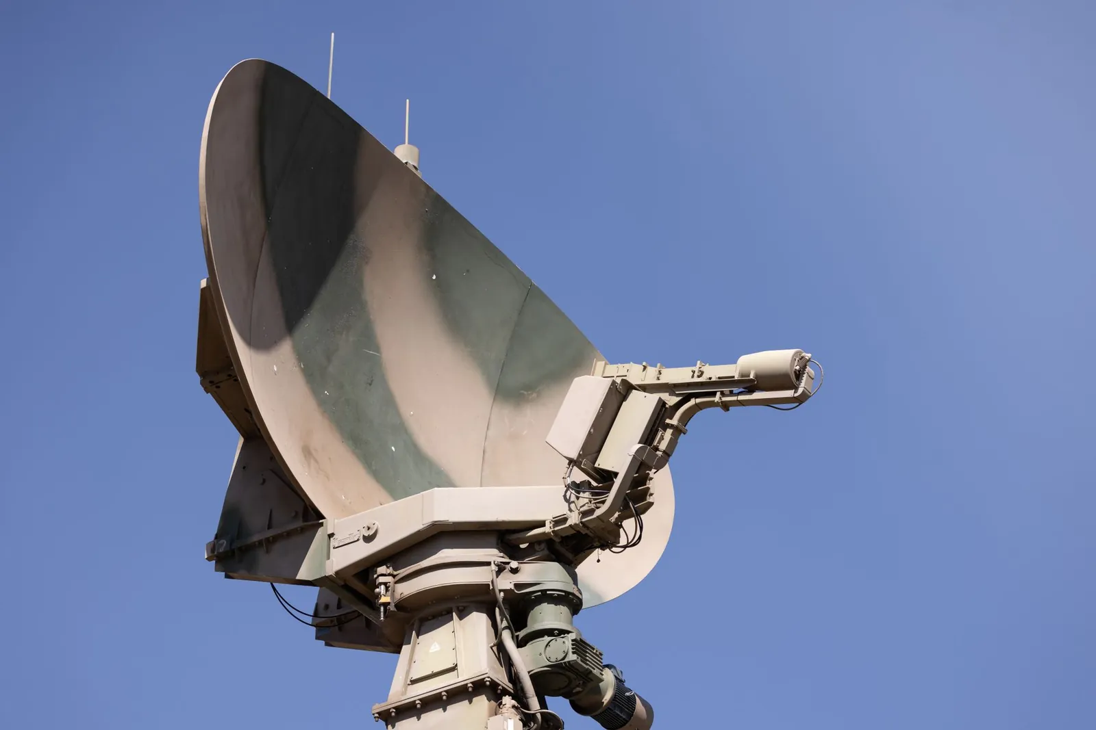 Close-up of a military radar system with a clear blue sky as background, showcasing advanced communication technology. Stock photo illustrating Data Patterns (India)'s new order story.
