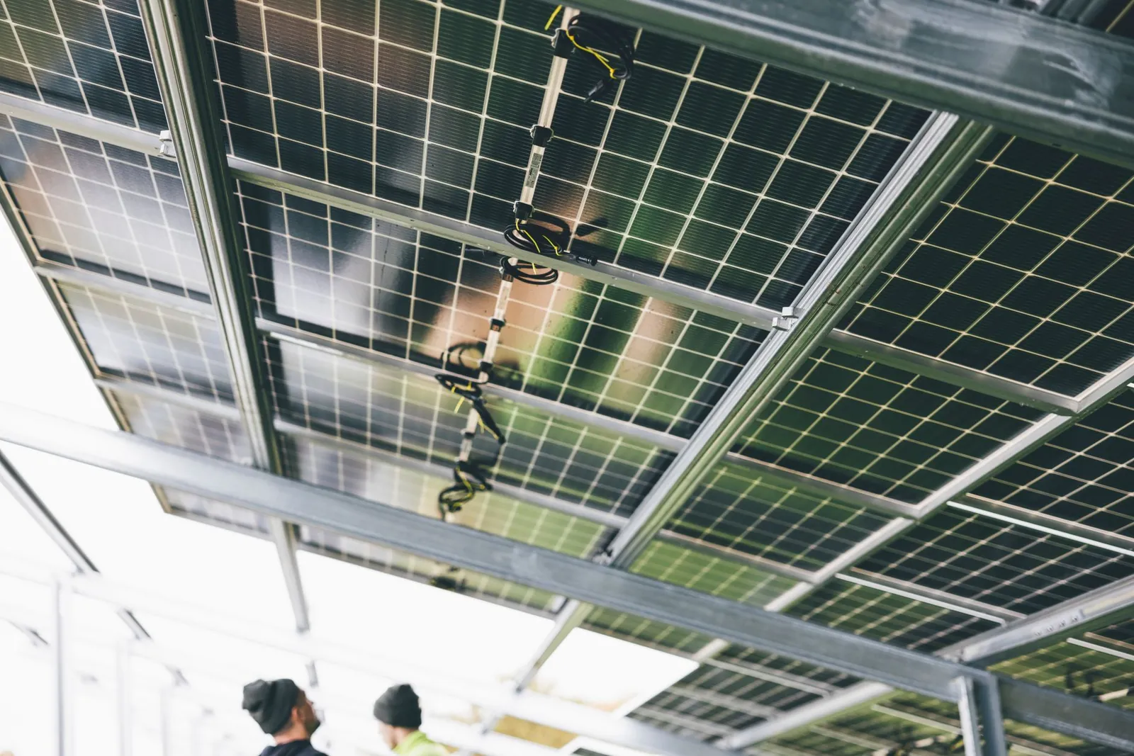 Close-up of solar panels being installed outdoors with technicians visible. Stock photo illustrating GRE Renew Enertech's new order story.