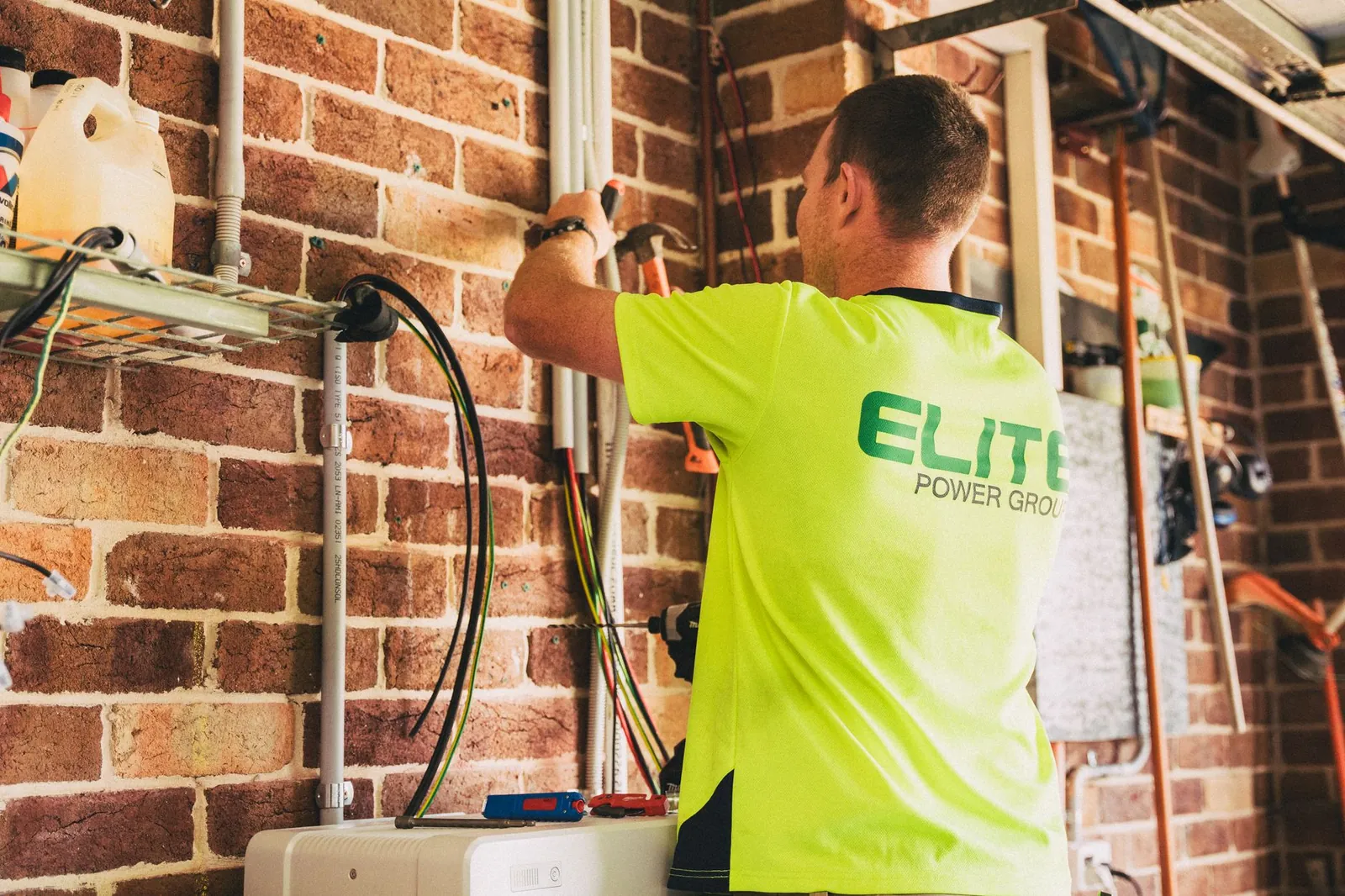 Electrician performing solar battery installation for sustainable energy storage in a home setting. Stock photo illustrating GK Energy's new order story.