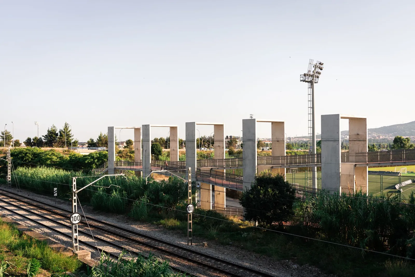 Modern railroad tracks with cables surrounded by green trees and concrete constructions on sunny day. Stock photo illustrating SRM Contractors' new order story.