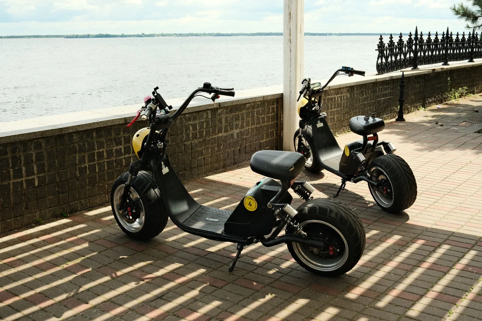 Two modern electric scooters parked on a riverside promenade, reflecting eco-friendly urban transportation. Stock photo illustrating Hero MotoCorp's product launched story.