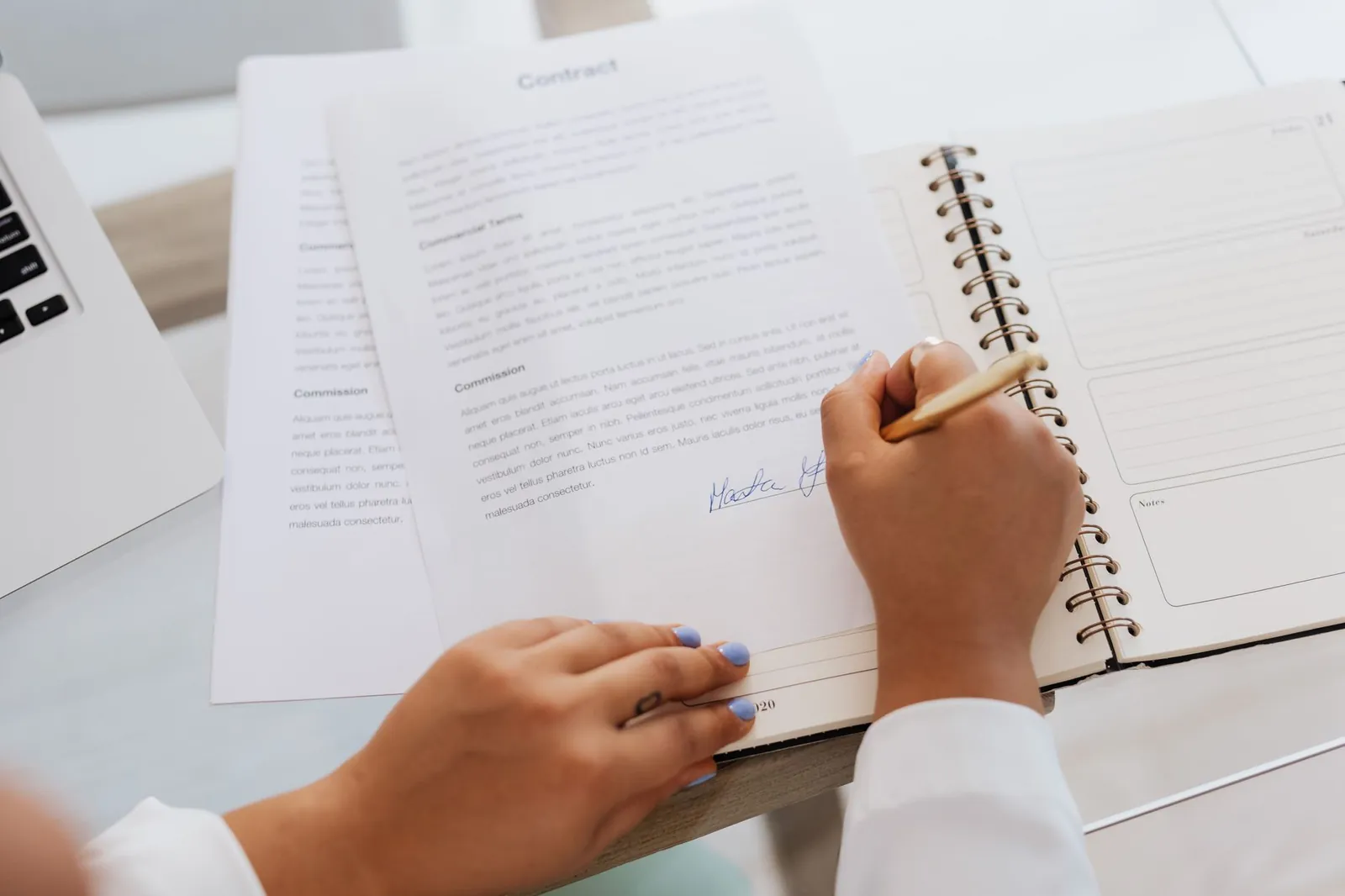 Close-up of hands signing a contract on a desk with office supplies, symbolizing legal agreements. Stock photo for the ALFA News guide: Material Subsidiary Disclosure: SEBI Rules for Investors.