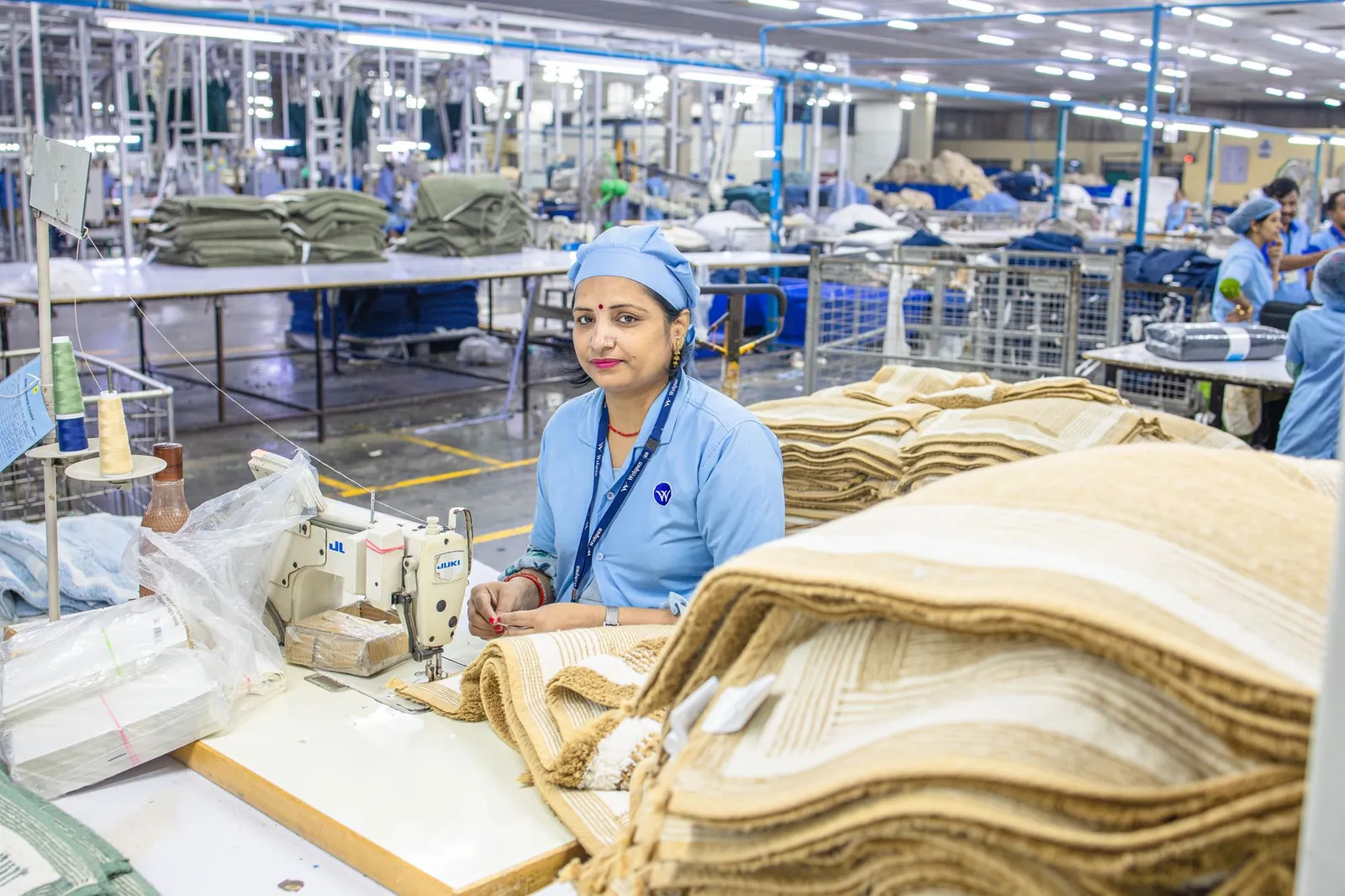Indian factory worker in textile mill showcasing industrial production process. Stock photo illustrating Sarveshwar Foods' fund raise story.